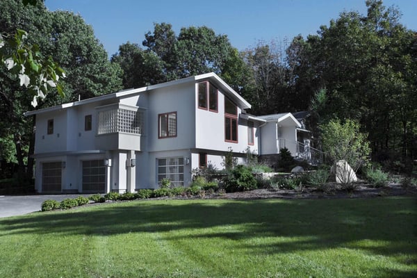 Contemporary home design featuring clean lines, spacious windows, and lush greenery, showcasing expert craftsmanship in Harvard, MA