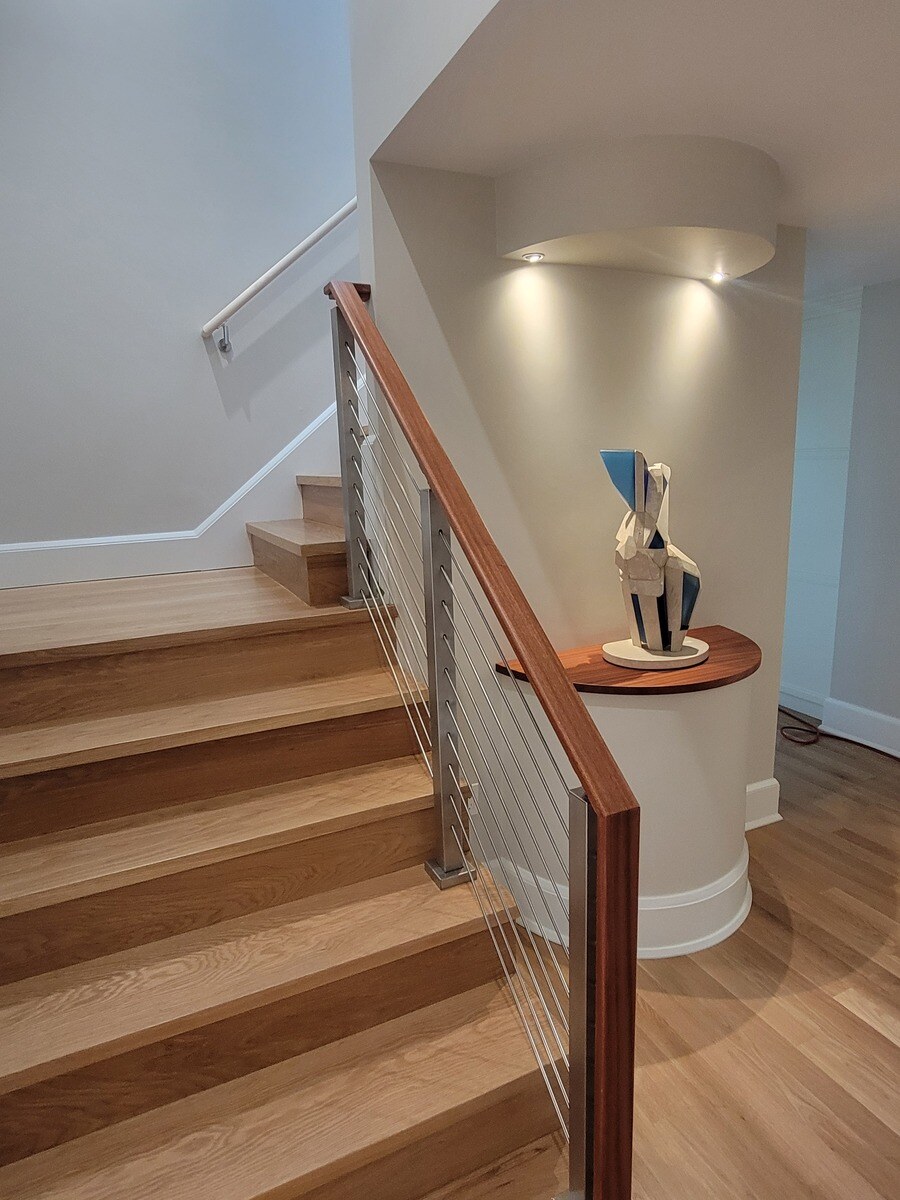 Contemporary staircase design featuring clean lines and a sculptural accent piece, created by Thomas Buckborough & Co. in Harvard, MA Contemporary staircase design featuring clean lines and a sculptural accent piece, created by Thomas Buckborough & Co. in Harvard, MA