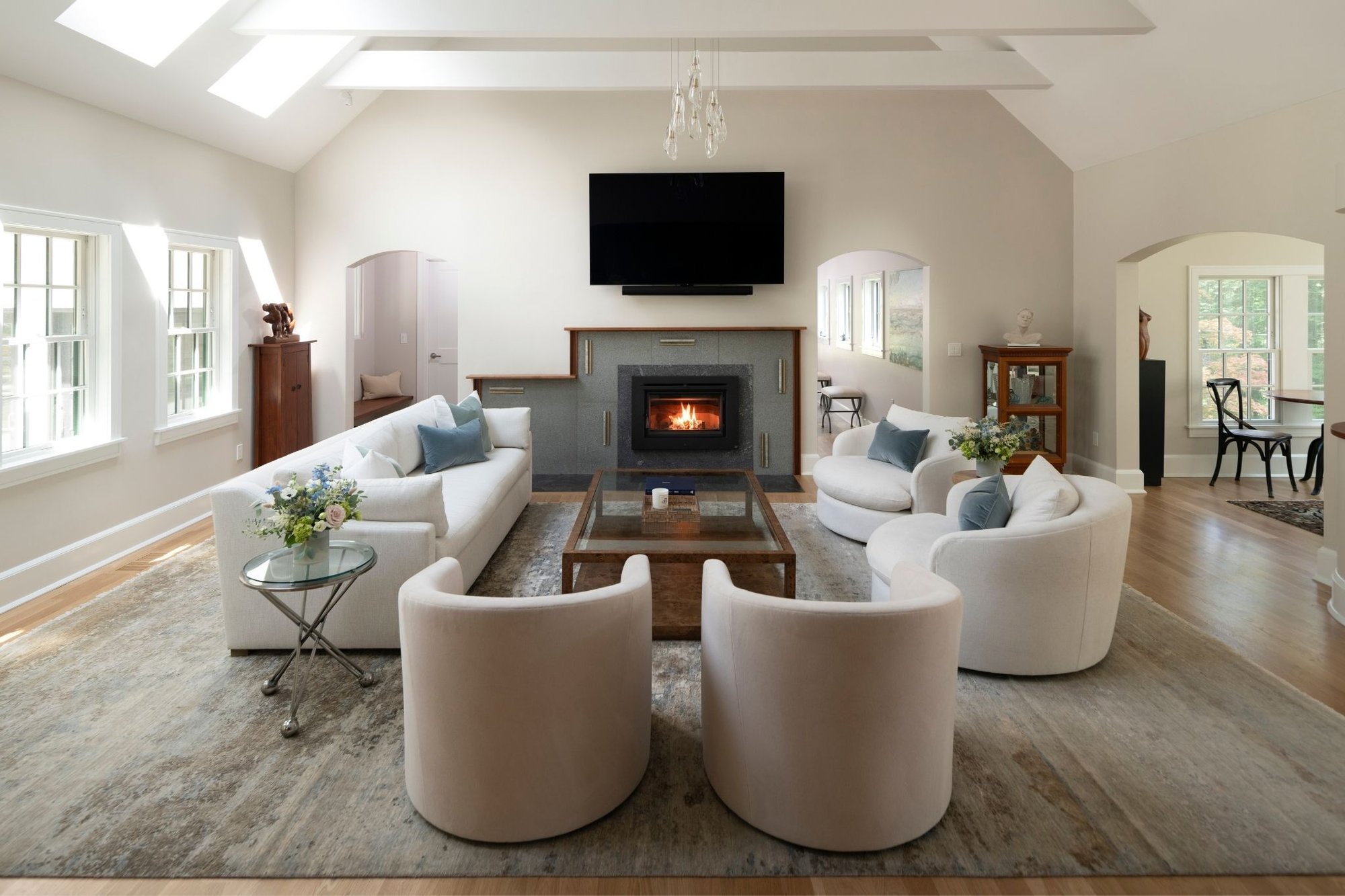 whole home renovation in acton with vaulted ceilings and fireplace in a bright, white living room