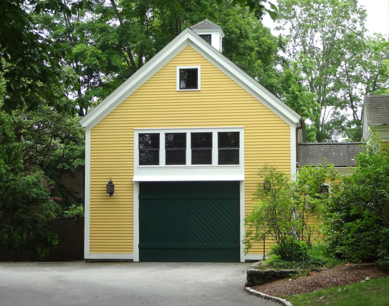 Yellow garage with a living space above it.