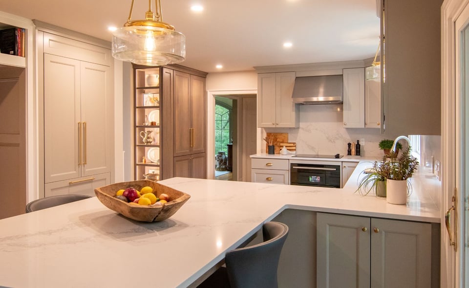Modern gray kitchen with shaker cabinets, white quartz countertops, and a large island, opening into a bright living room.Modern gray kitchen with shaker cabinets, white quartz countertops, and a