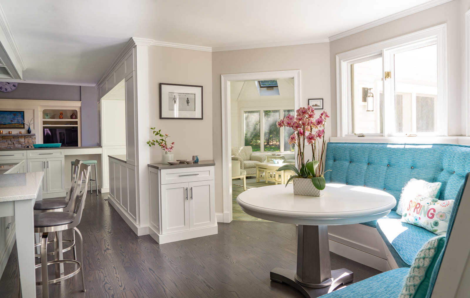 Bright and airy breakfast nook with a contemporary white table and plush seating in a kitchen renovation by Thomas Buckborough & Associates in Acton, MA
