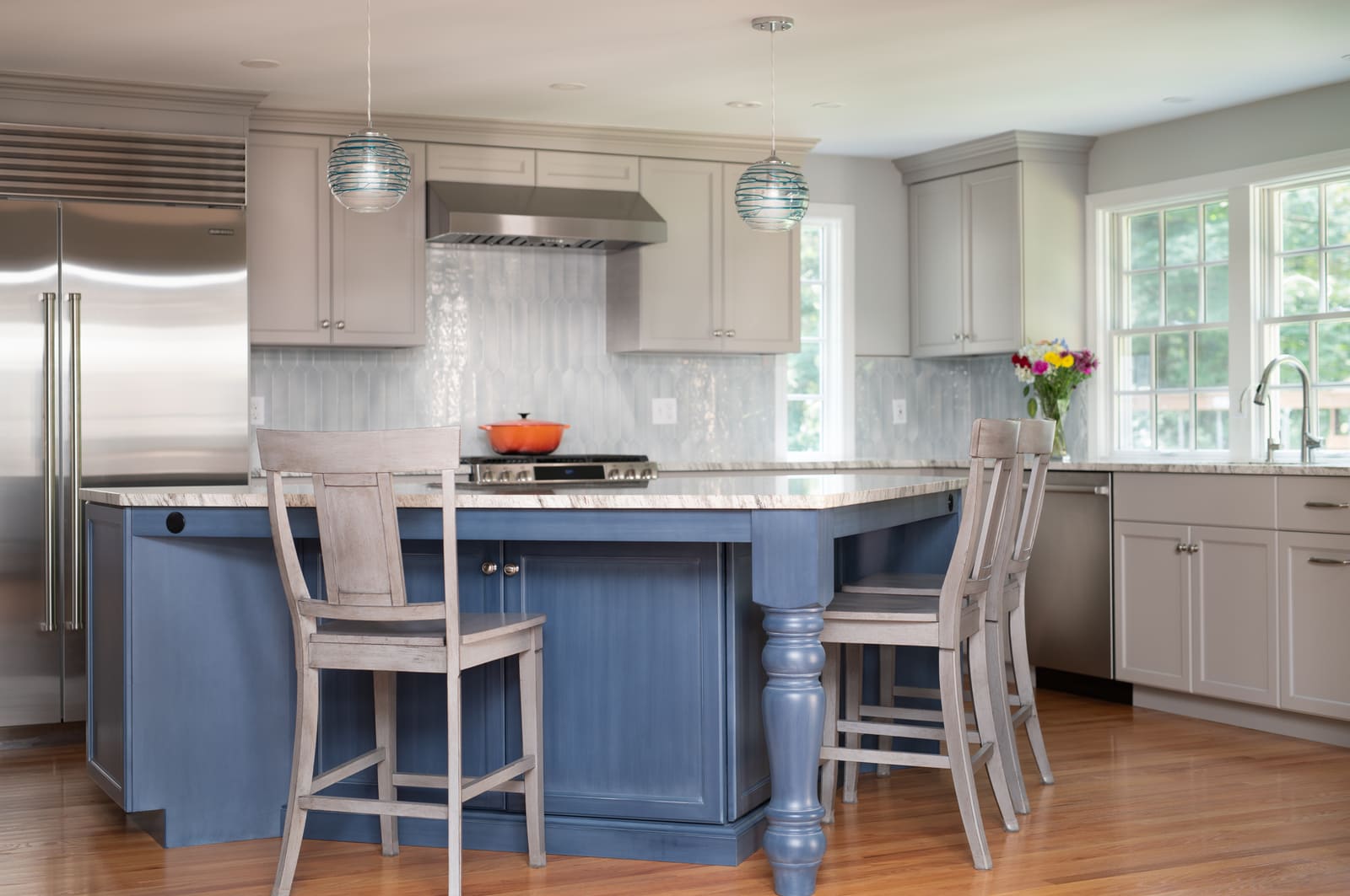 Elegant kitchen remodel by Thomas Buckborough & Associates with a mix of blue and gray cabinetry, wood flooring, and ample natural light Elegant kitchen remodel by Thomas Buckborough & Associates with a mix of blue and gray cabinetry, wood flooring, and ample natural light