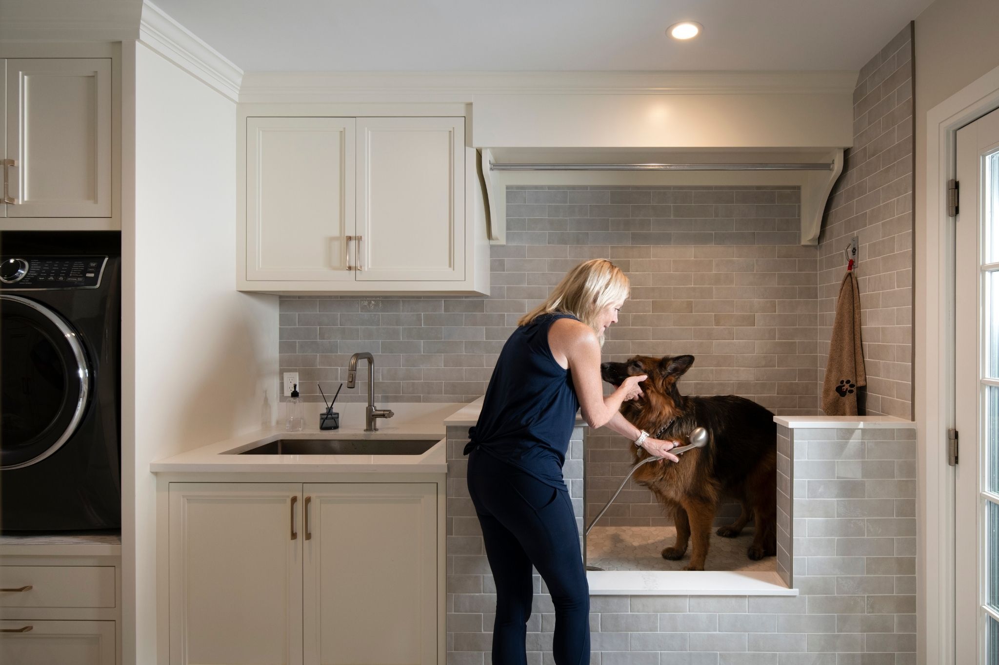 custom mudroom in acton, massachusetts with dog shower, laundry, and white cabinetry